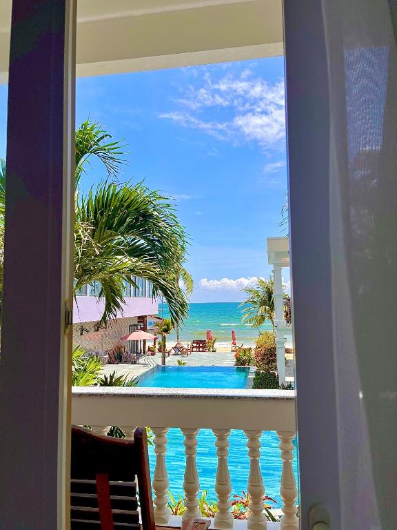 Pool meeting the ocean beneath the palms